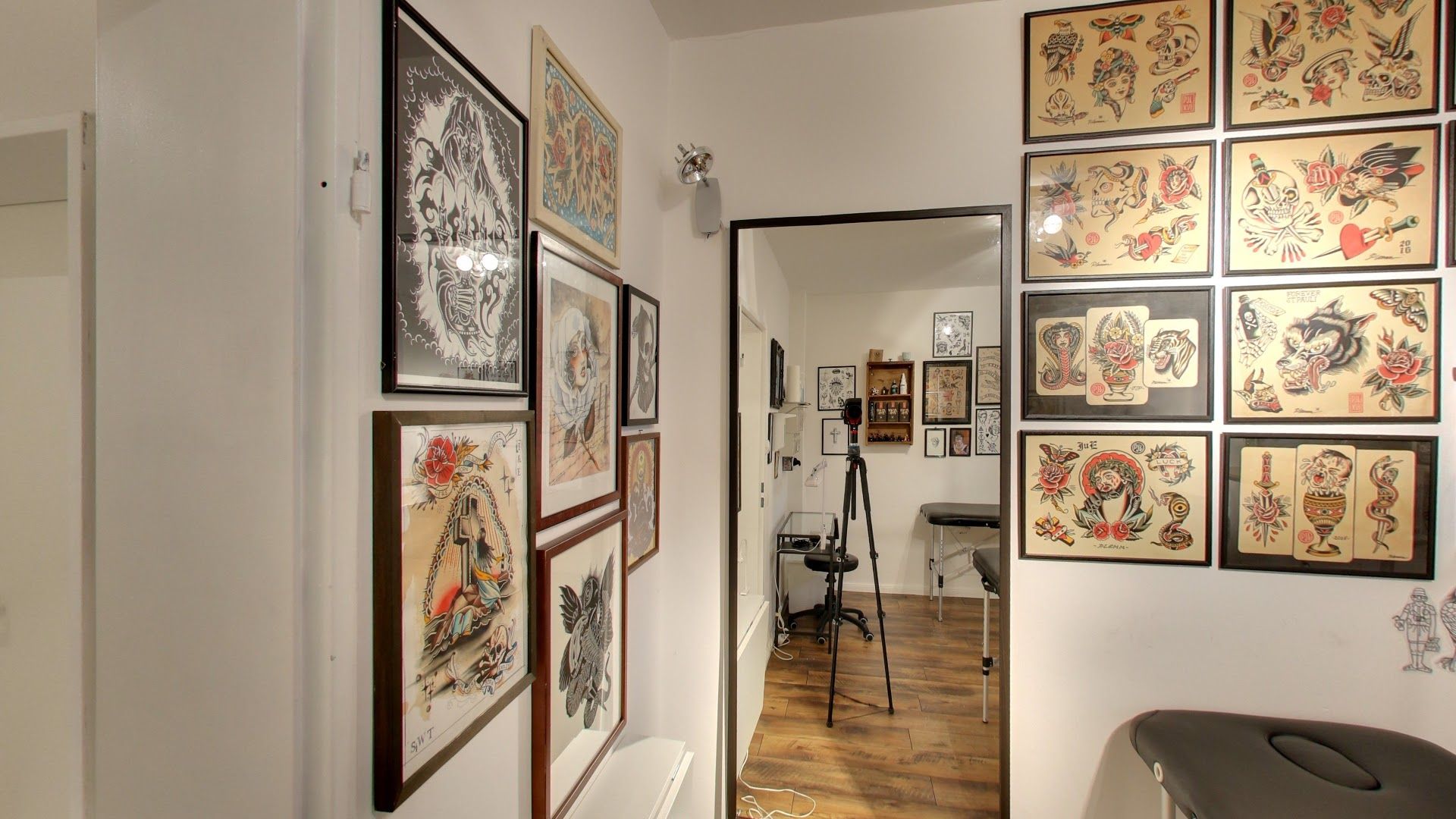 a hallway with a wall of framed art