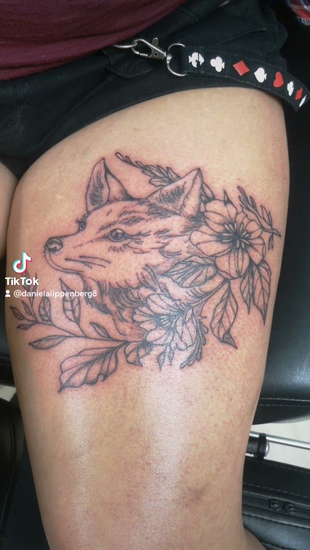 a narben tattoo of a wolf with flowers on the thigh, ansbach, germany
