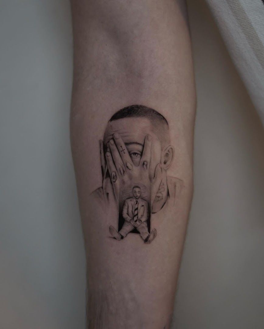 a man's arm with a black and white narben tattoo of a man's face, berlin, germany