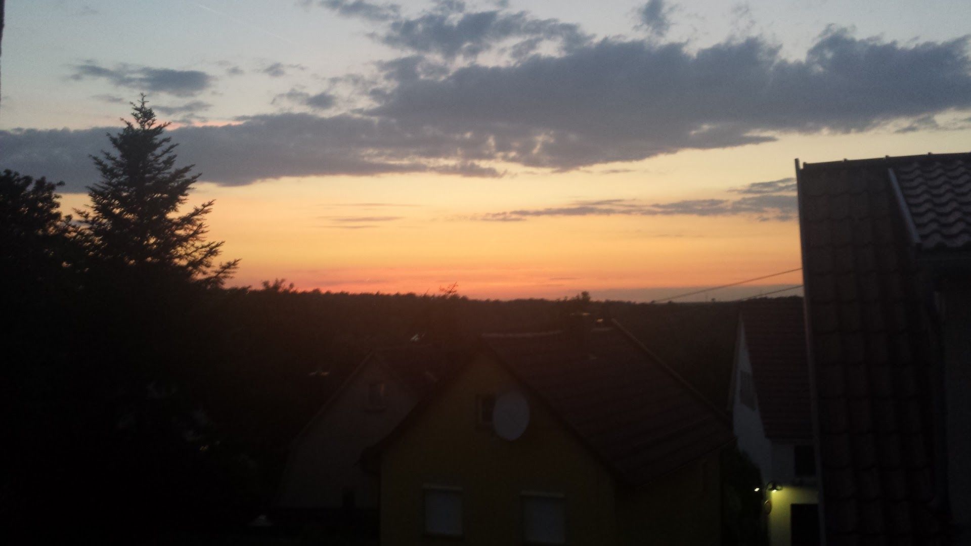 a sunset view from a rooftop of a house