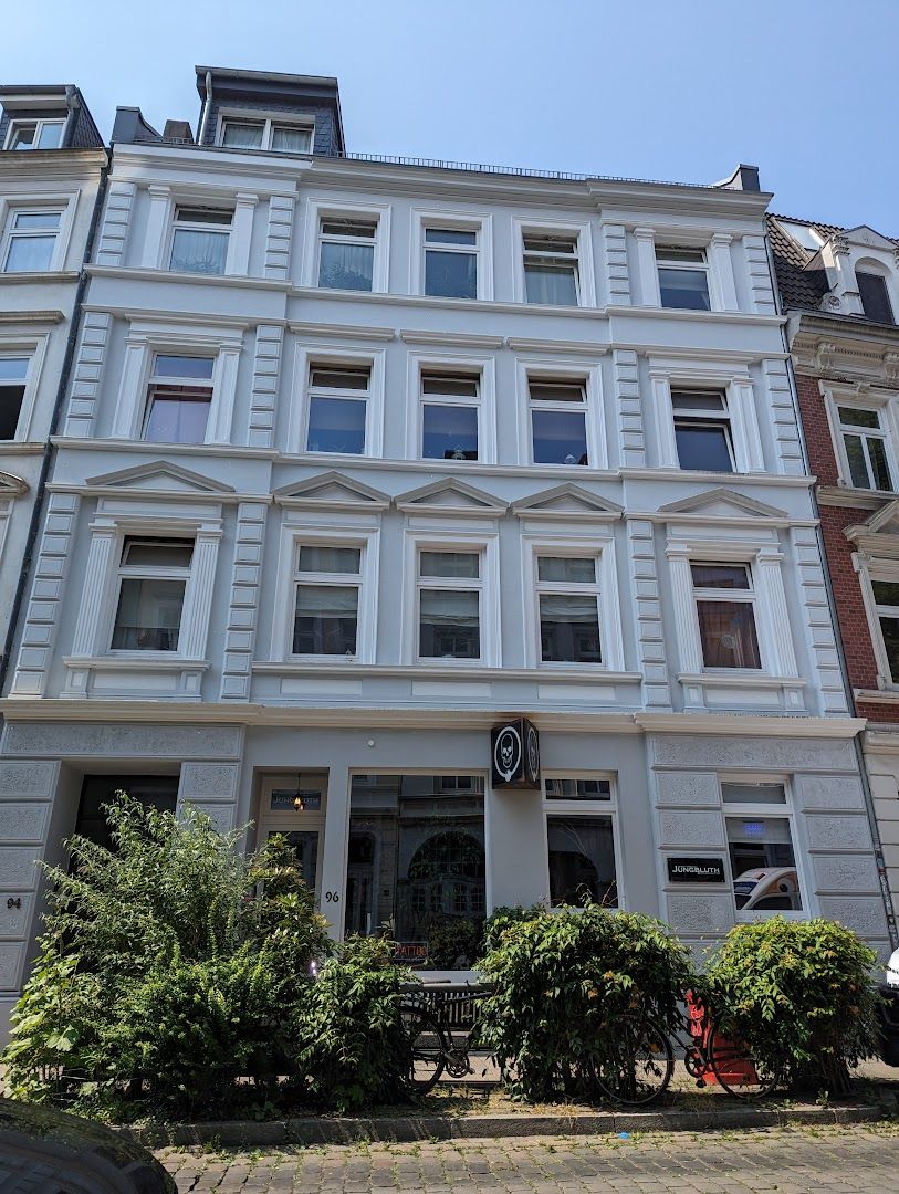 a white building with many windows and a bicycle parked in front