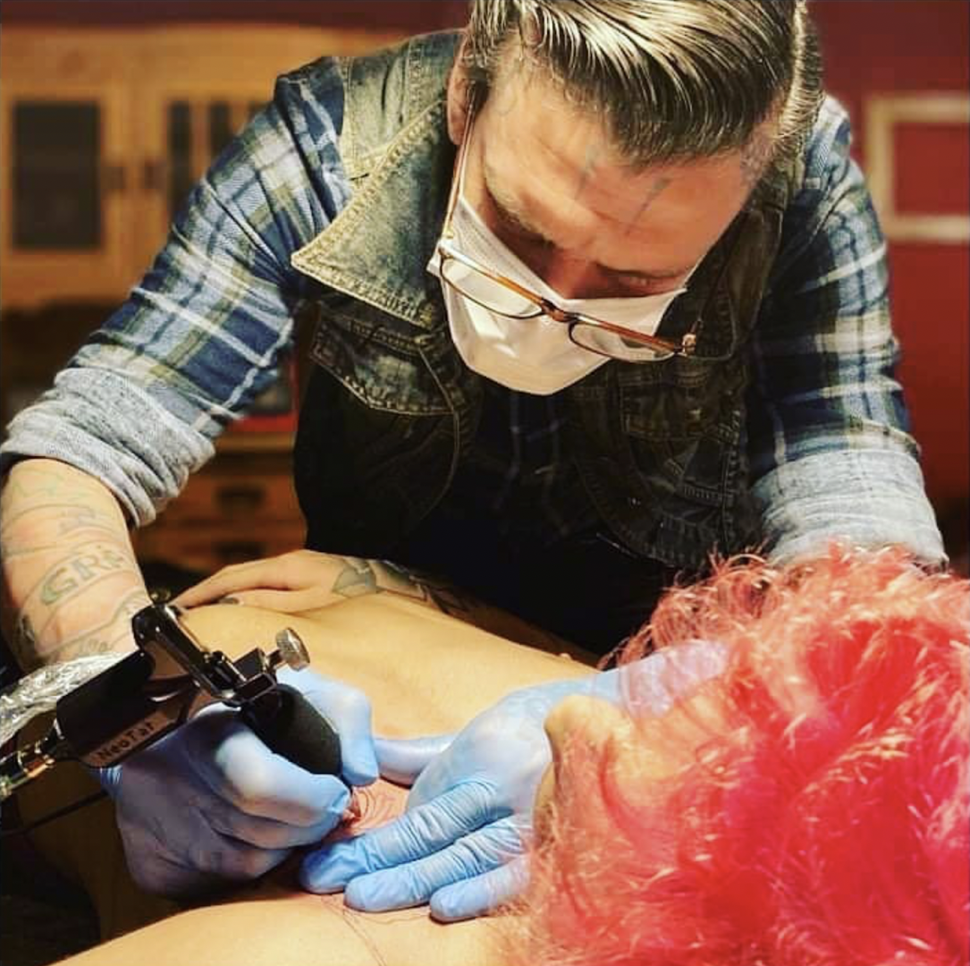 a man getting a cover-up tattoo on his arm, berlin, germany