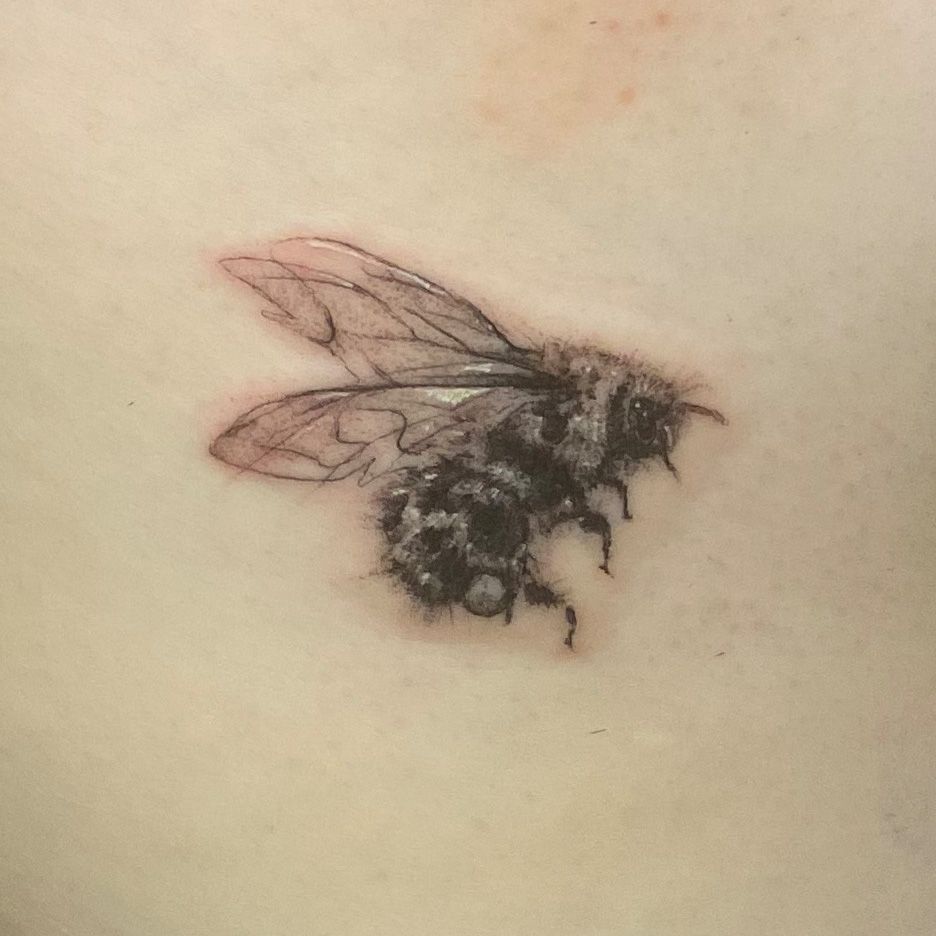 a narben tattoo of a bee on the back of a woman, freising, germany