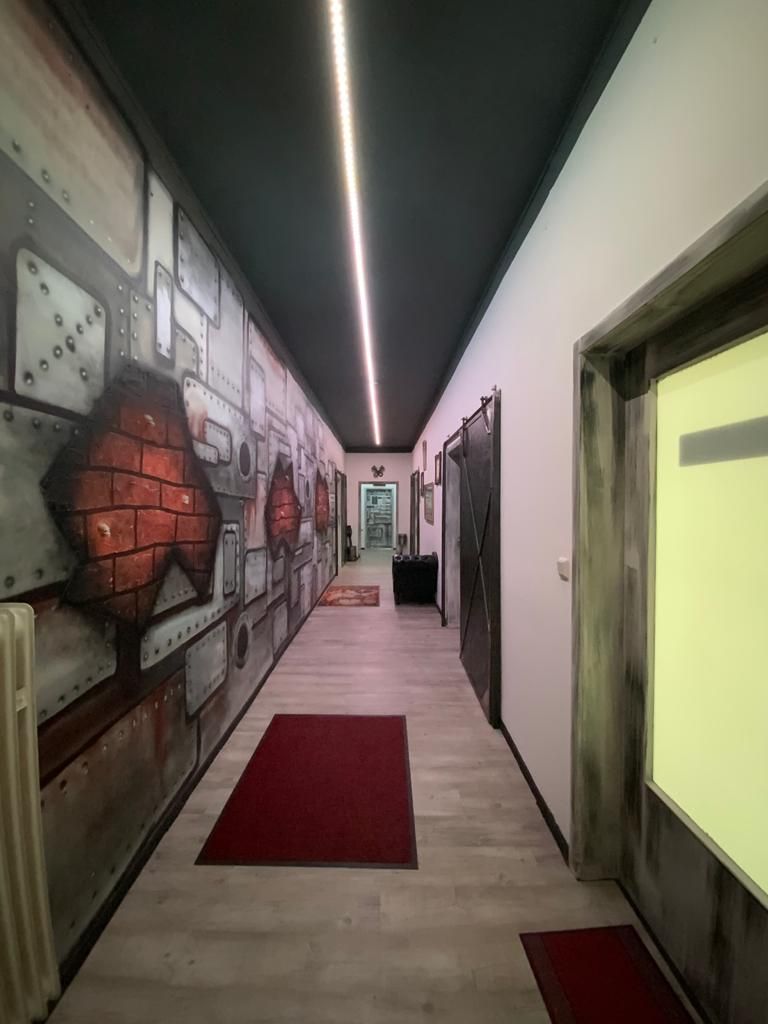 a hallway with a red carpet and a painting on the wall