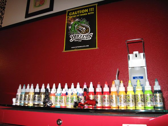 a red wall with a shelf filled with bottles of alcohol