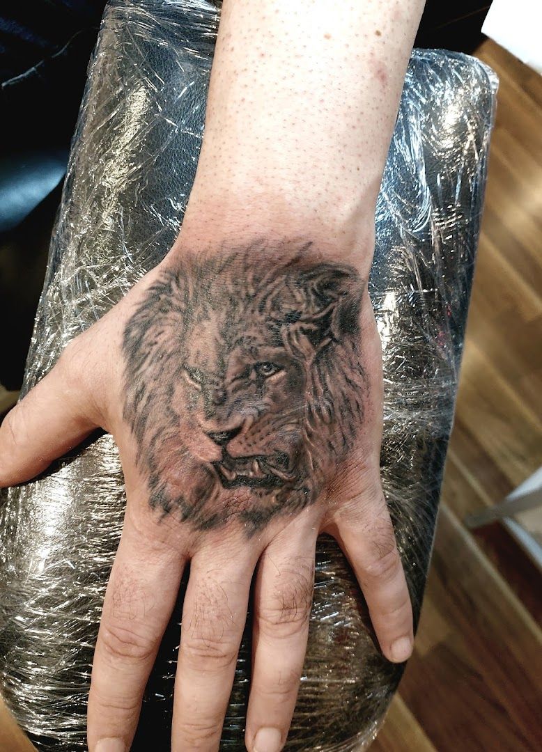 a narben tattoo of a lion on the hand, ansbach, germany