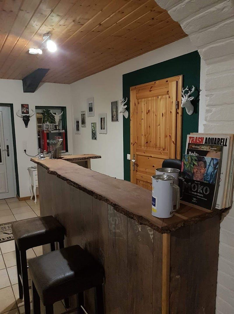 a bar with a wooden counter and a black chair