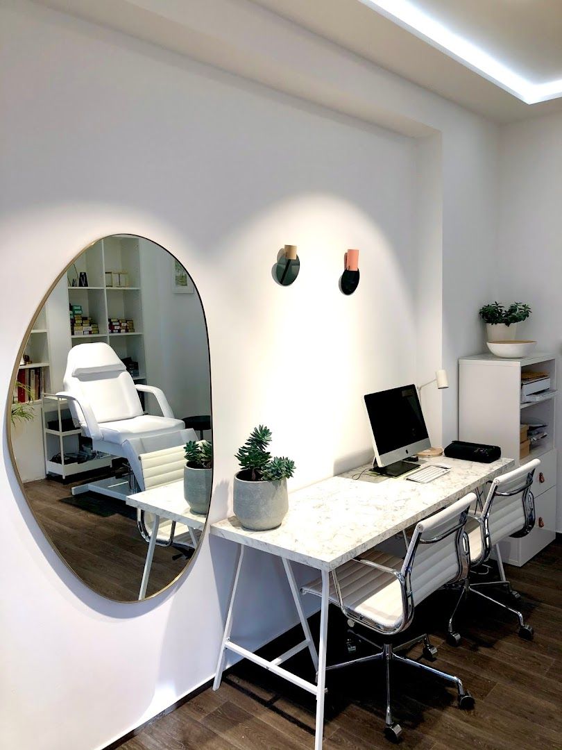 a white desk with a mirror and a laptop