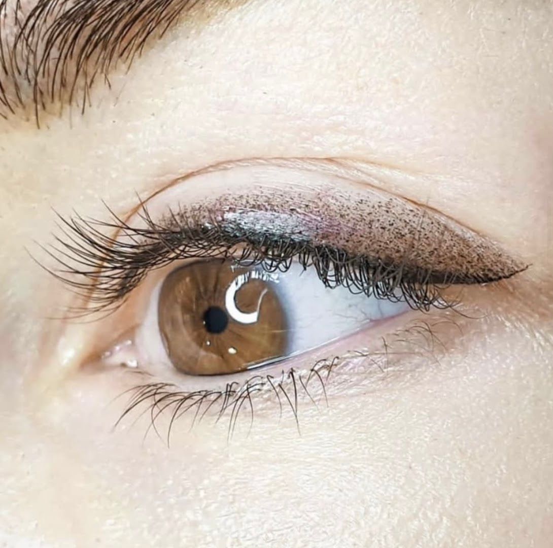 a woman's eye with long lashes and brown eyes