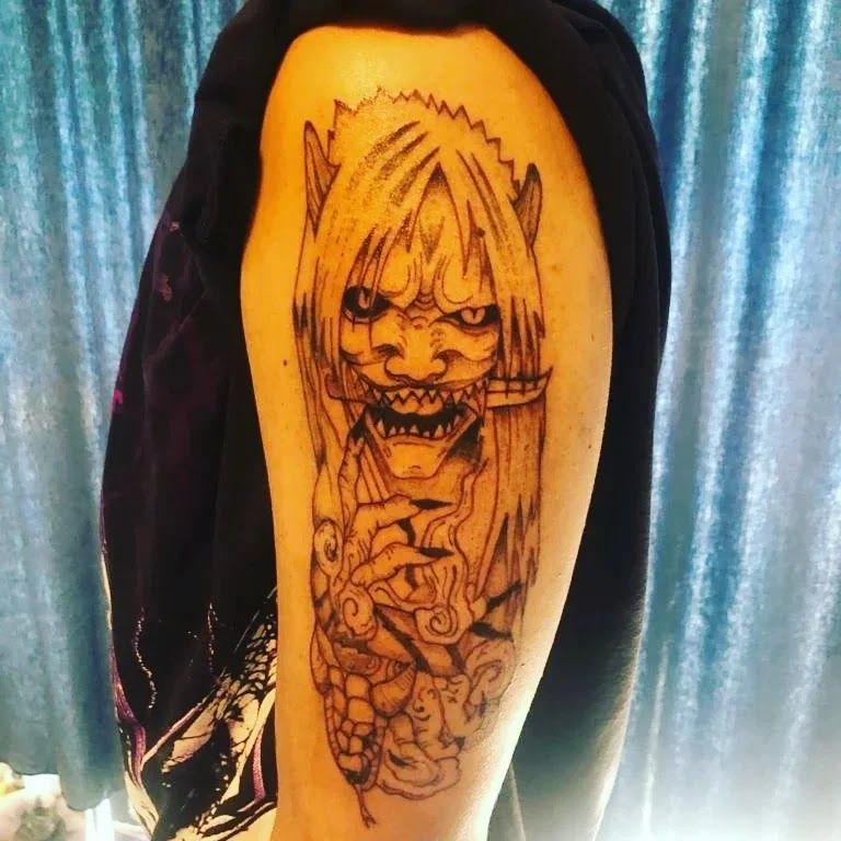 a narben tattoo of a demon with a demon head on the back of a man's arm, ansbach, germany