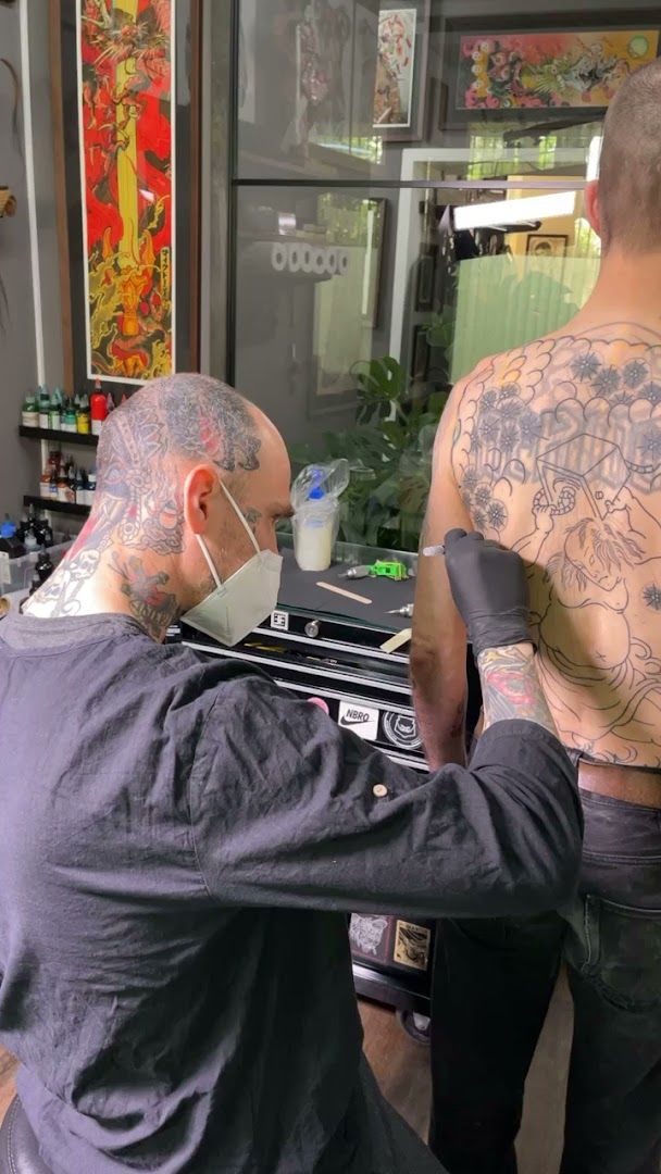 a man getting his narben tattoo done by a tattoo artist, berlin, germany