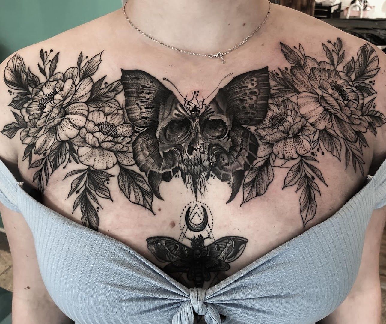 a woman with a butterfly and flowers on her chest