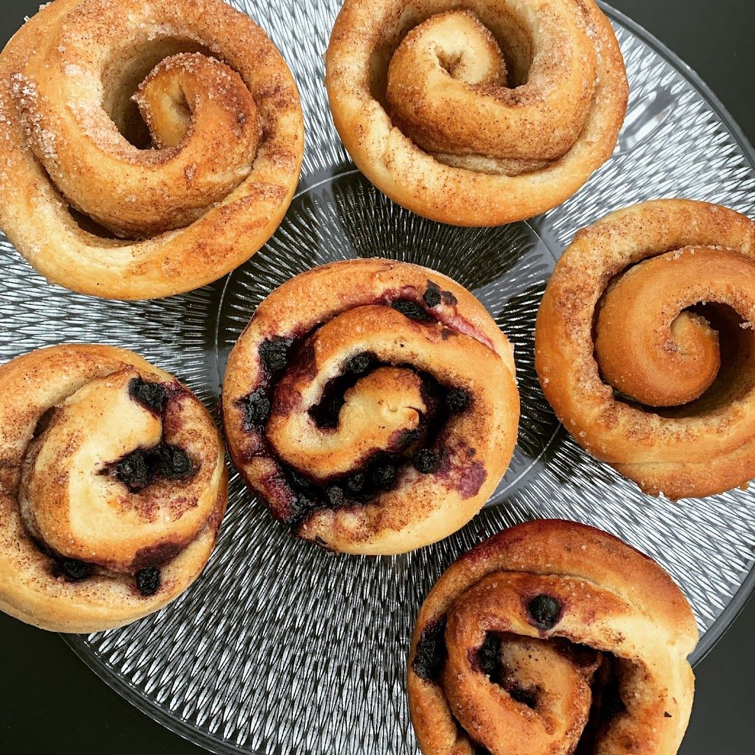 a plate of doughs with blueberries and a cup of coffee