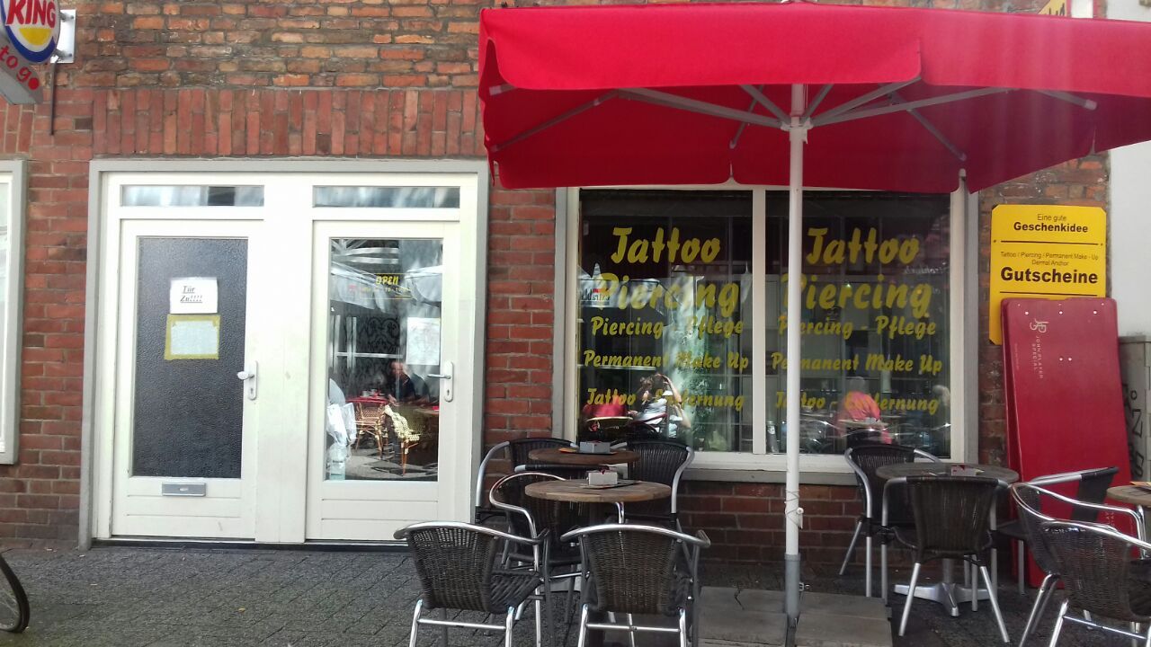 a restaurant with tables and umbrellas outside