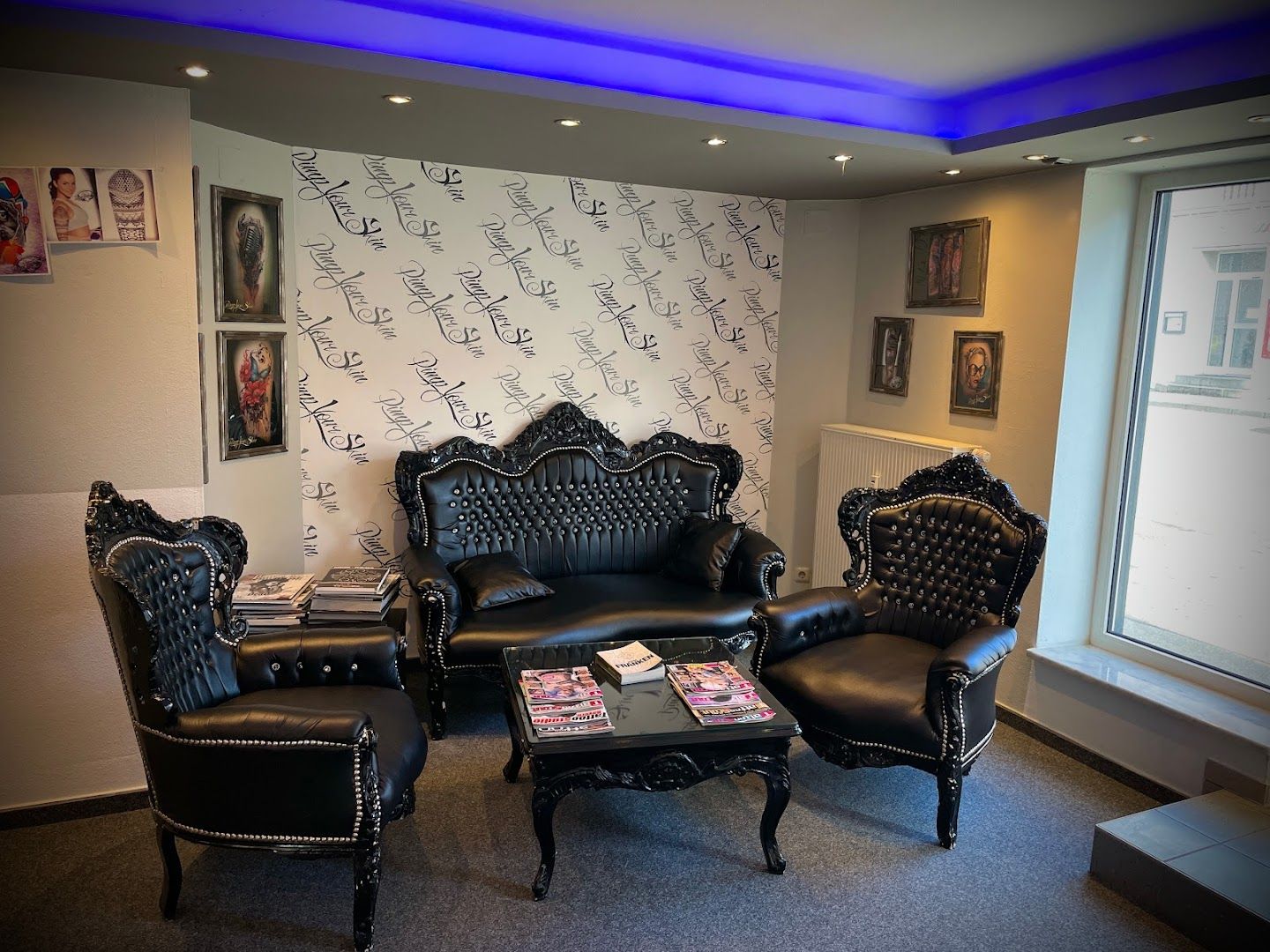 a room with black leather chairs and a wallpaper