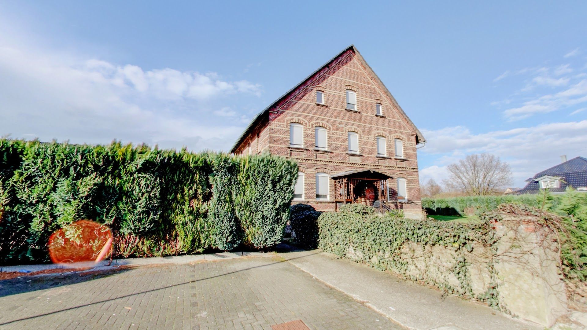 a brick house with a large garden in front