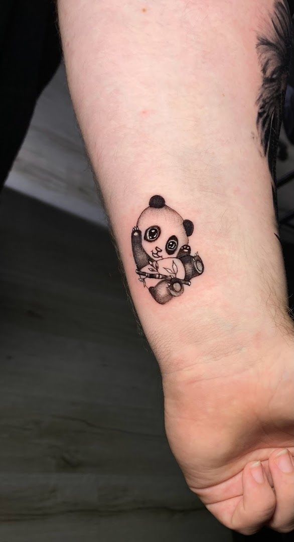 a small narben tattoo of a panda bear on the wrist, schaumburg, germany