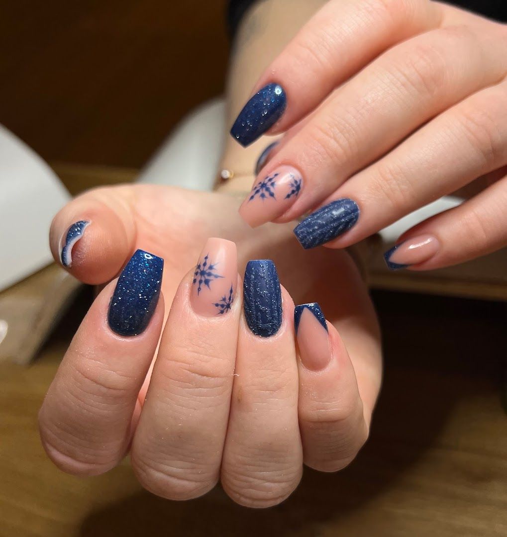 a woman's hands with blue nail polish and a white mani