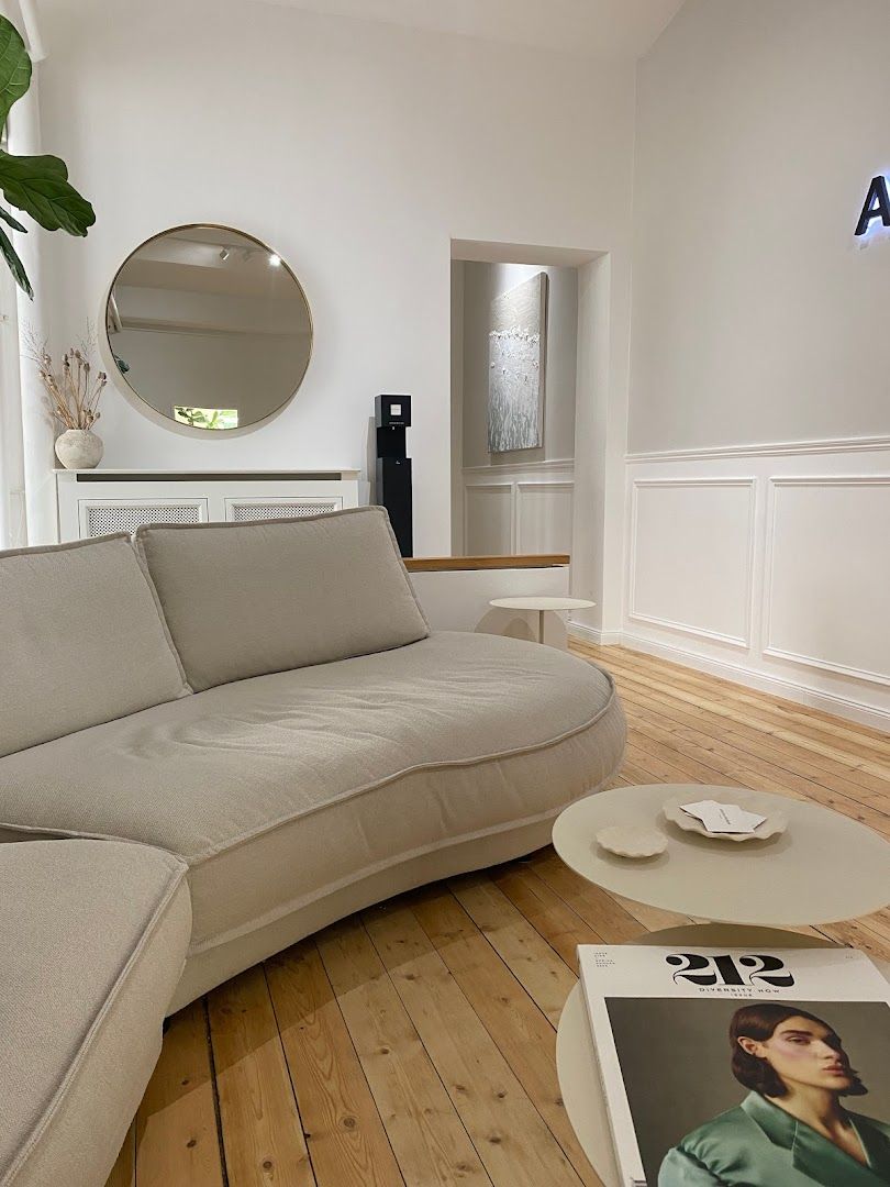 a couch in a living room with a mirror above it