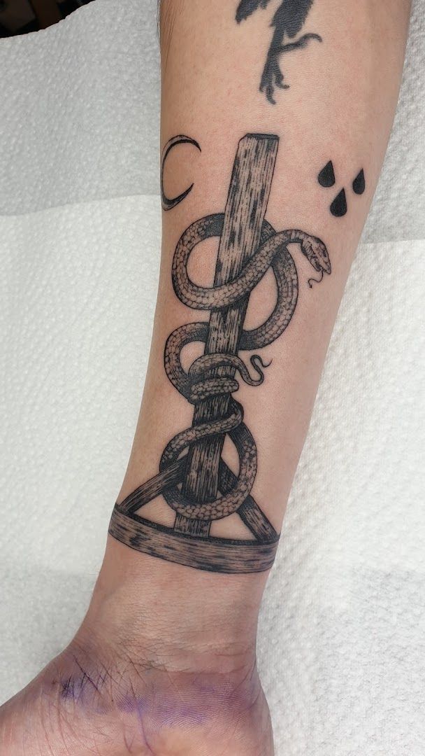 a narben tattoo of a cross and a snake on the wrist, bochum, germany