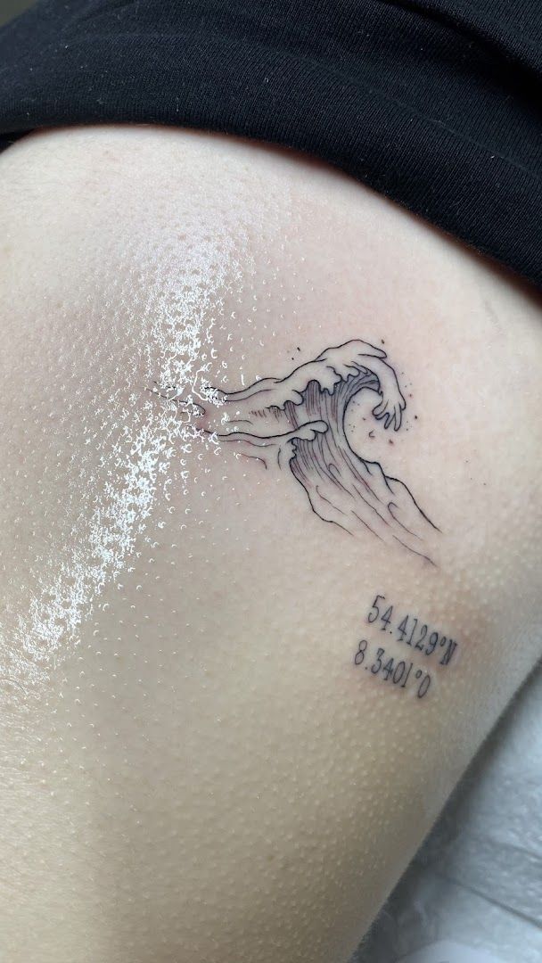 a cover-up tattoo of a wave with the words'life is a wave ', hamburg, germany