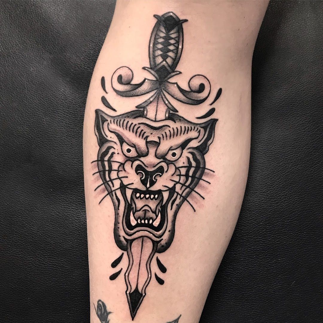 a cover-up tattoo of a tiger with a dagger on the leg, frankfurt, germany