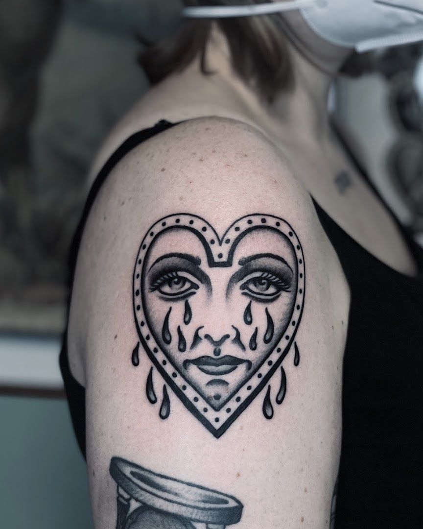 a woman's shoulder with a heart and a face