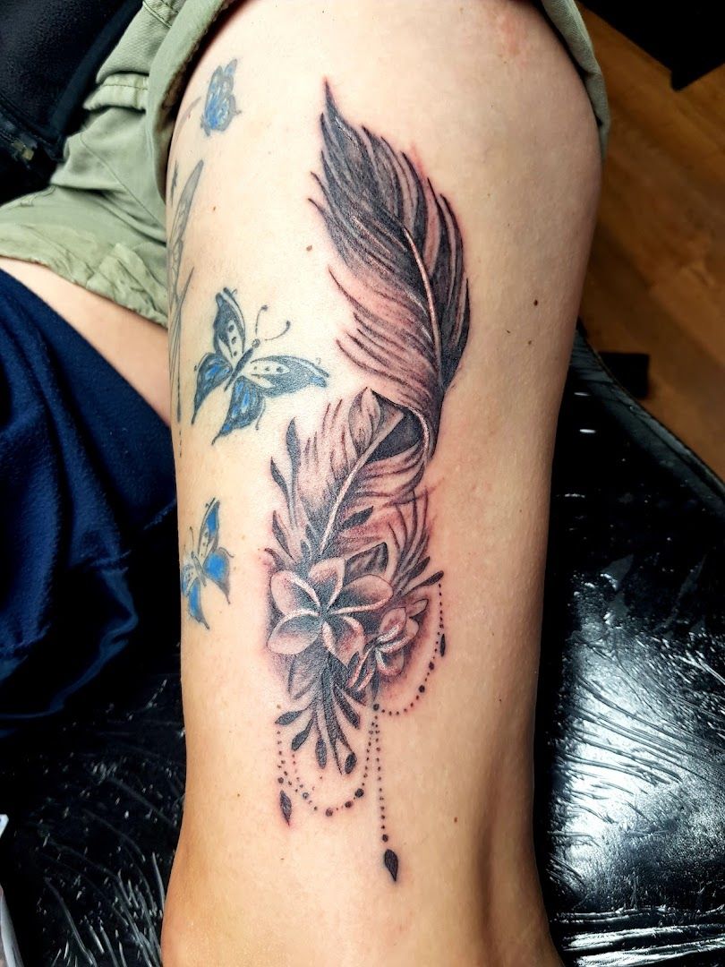 a narben tattoo with a feather and flowers on the leg, oder-spree, germany