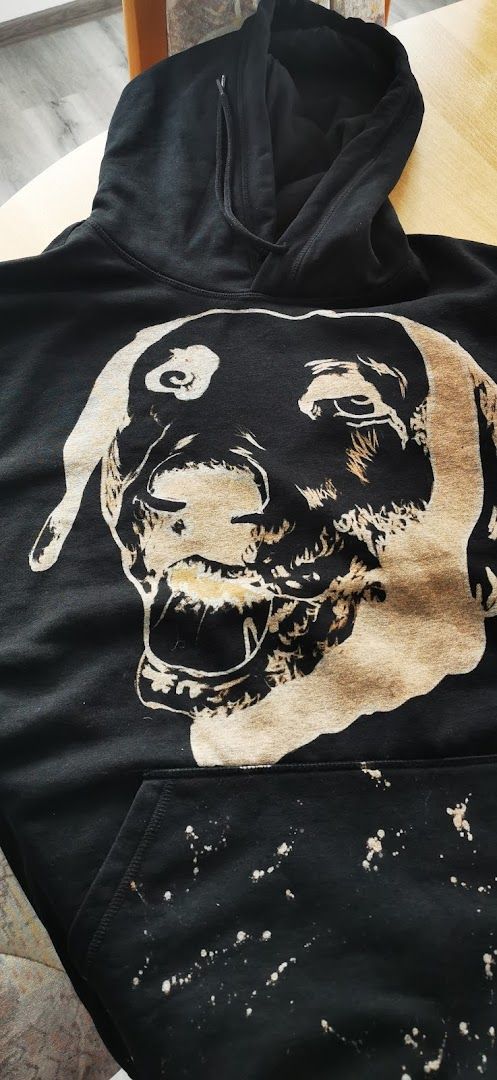 a black hoodie with a dog's face painted on it