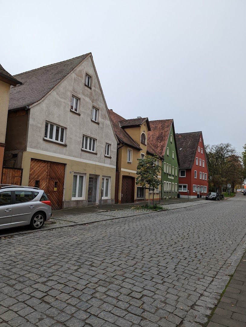 a cobbed street with houses and cars parked on it