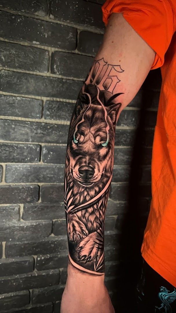 a man with a wolf cover-up tattoo on his arm, kassel, germany