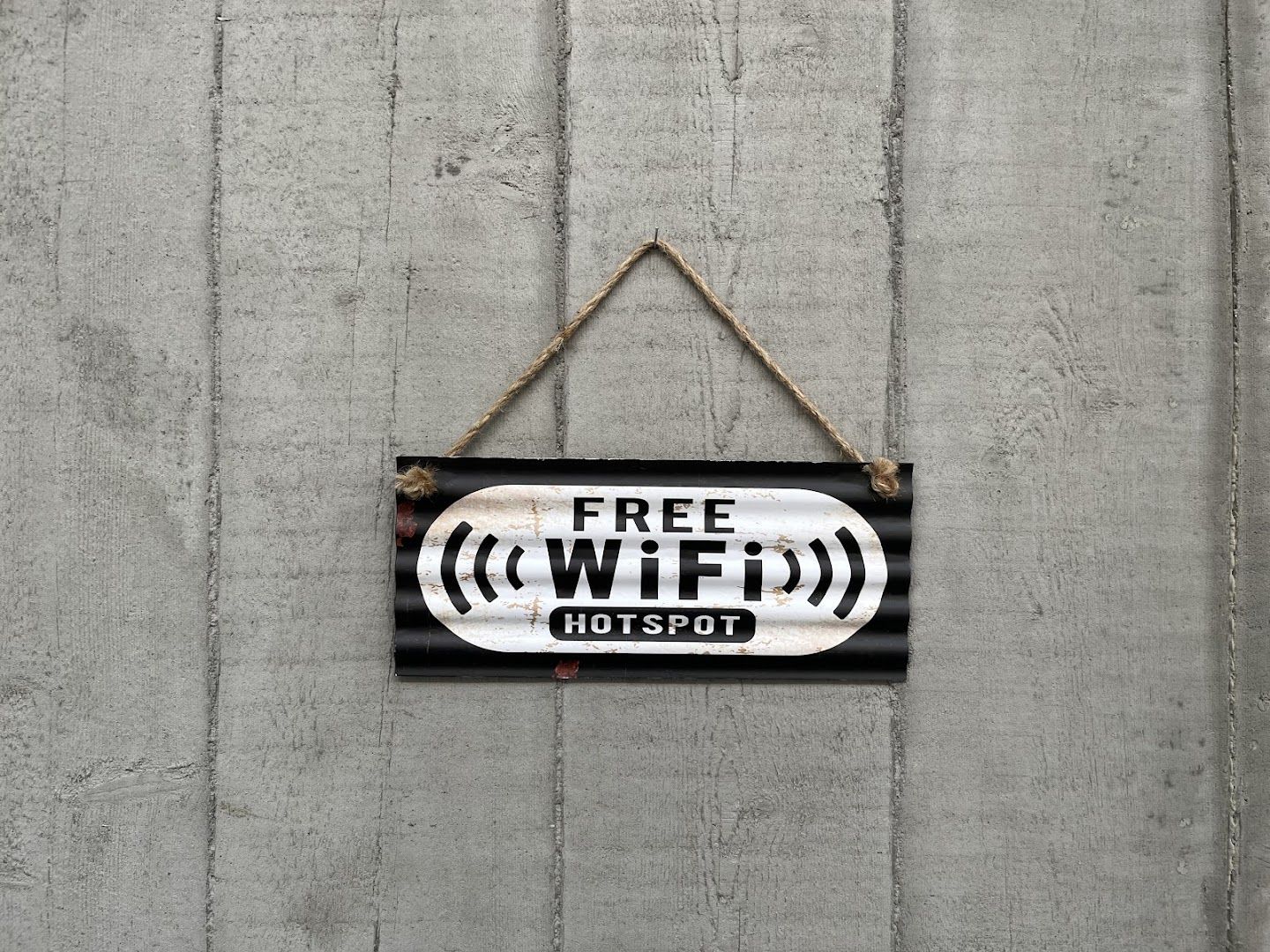 a sign hanging on a wall with a wooden background