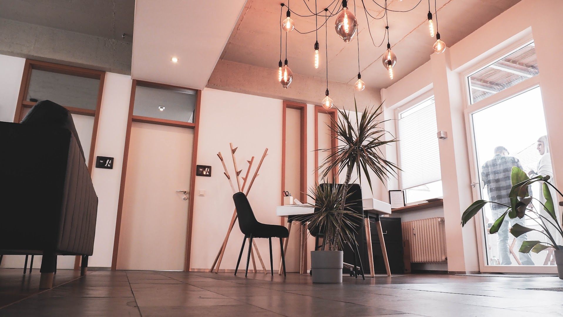 a room with a desk, chair and a plant