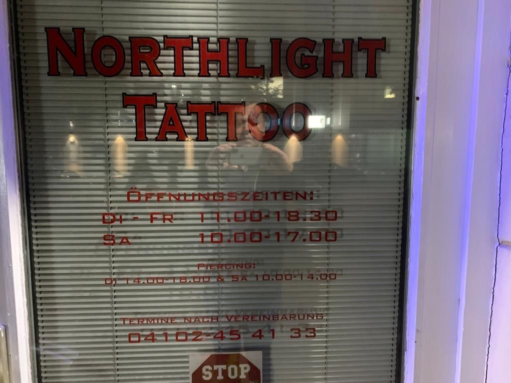 a sign on a window that says,'north narben tattoo ', stormarn, germany