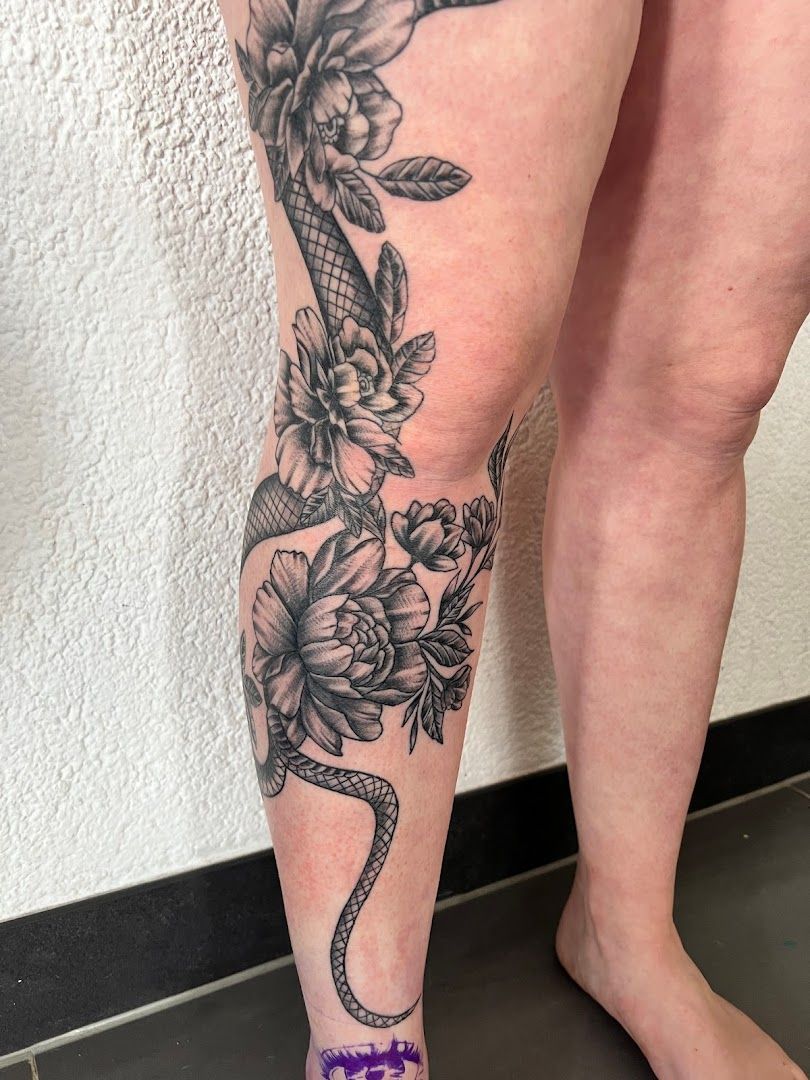 a woman's leg with a snake and flowers cover-up tattoo, kaiserslautern, germany