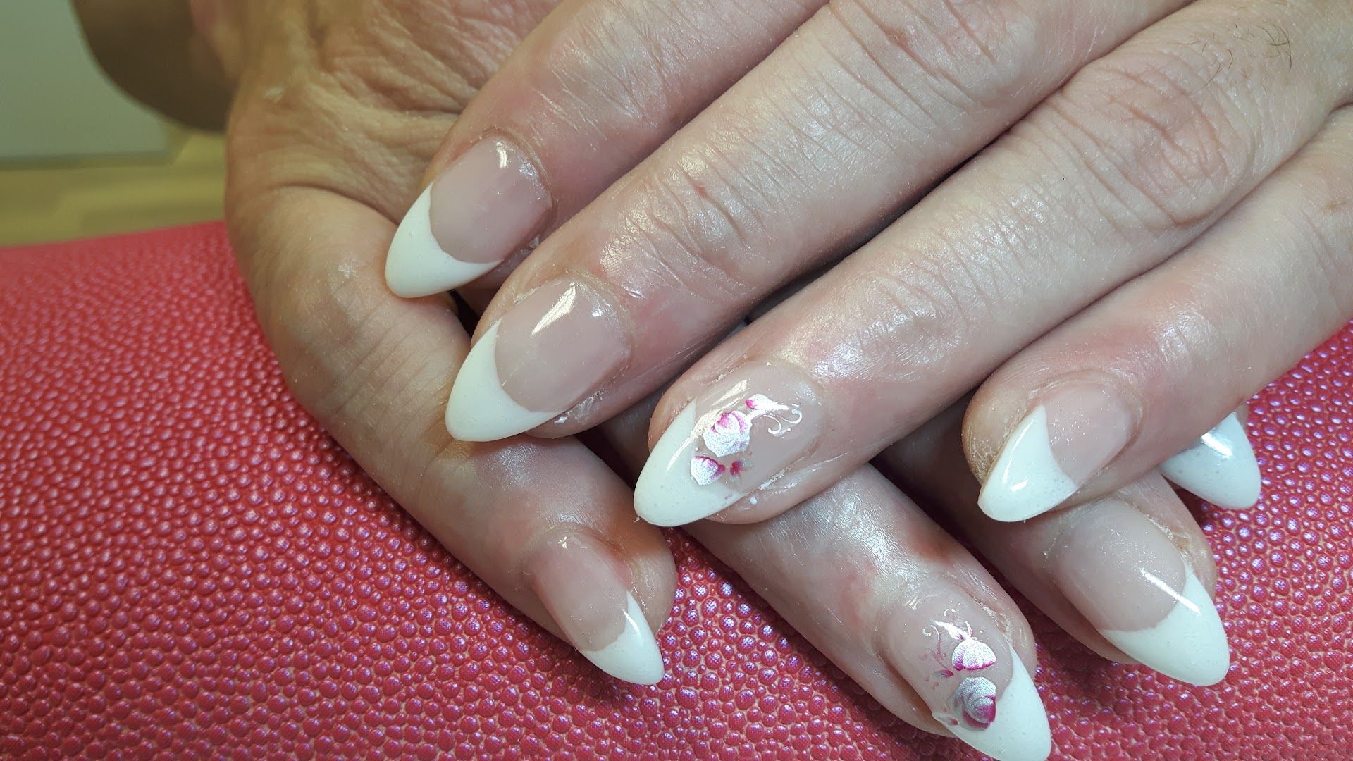 a woman's hands with white and pink french manies