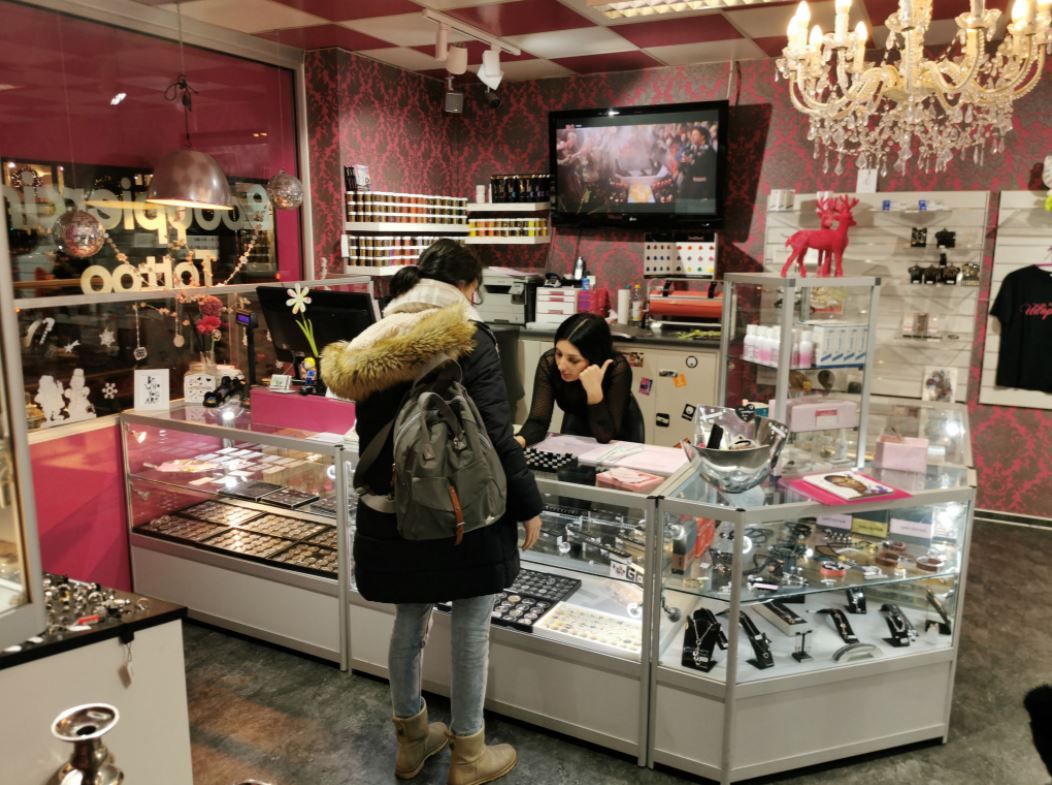 a woman is looking at a display of makeup products