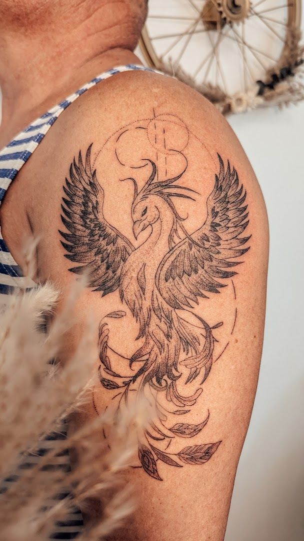 a narben tattoo of a bird with wings on the shoulder, vulkaneifel, germany