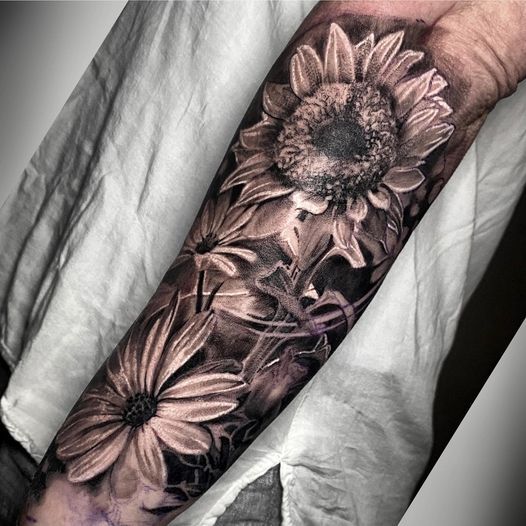 a black and white blackwork tattoo with flowers on the arm, nürnberg, germany