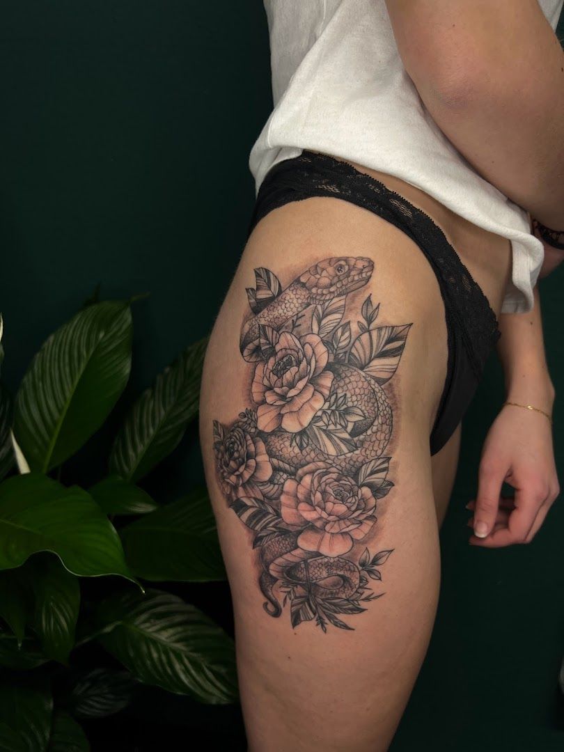 a woman's thigh with a narben tattoo of flowers and leaves, rhein-hunsrück-kreis, germany