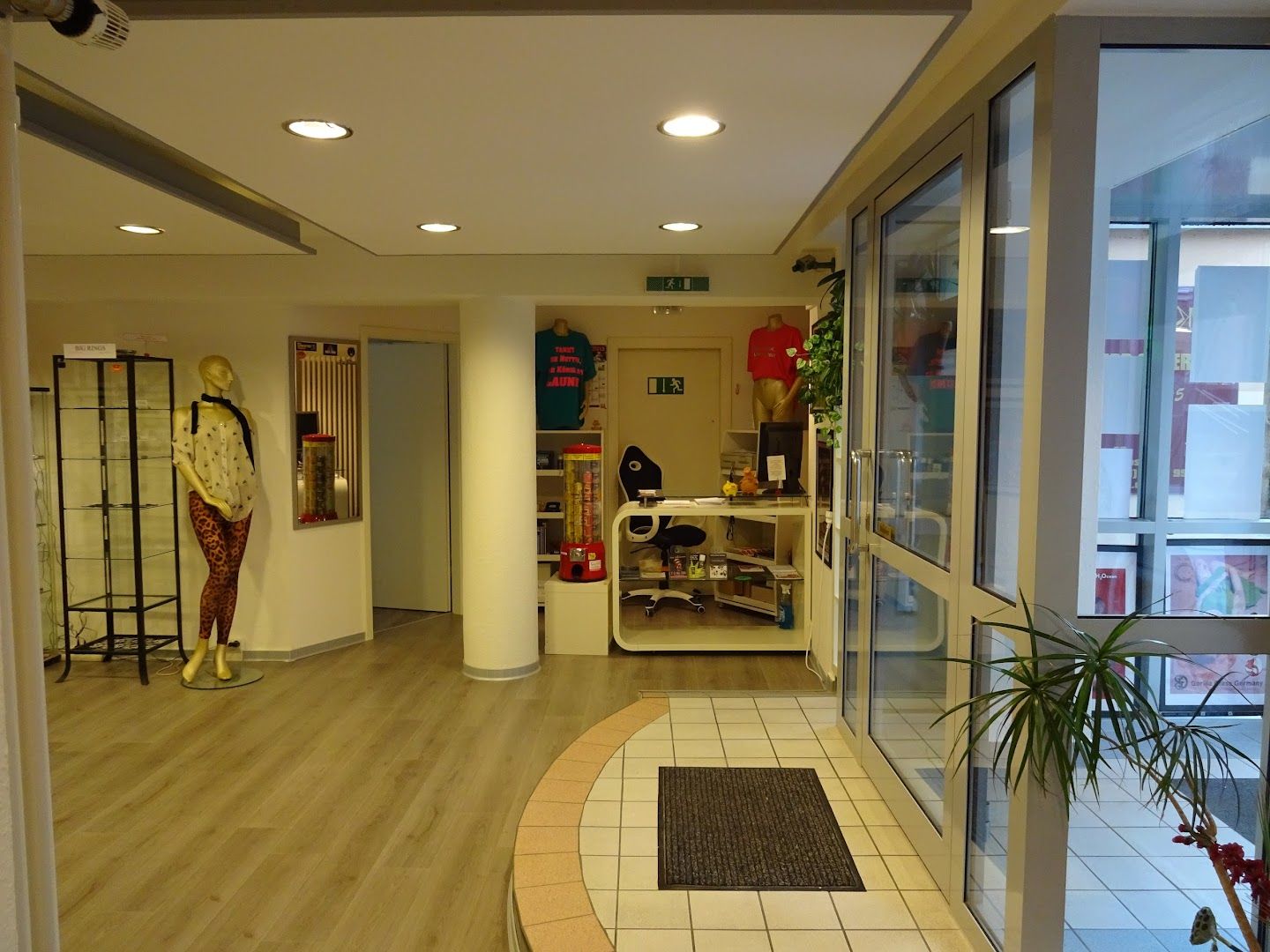 a hallway with a white tiled floor and a white wall