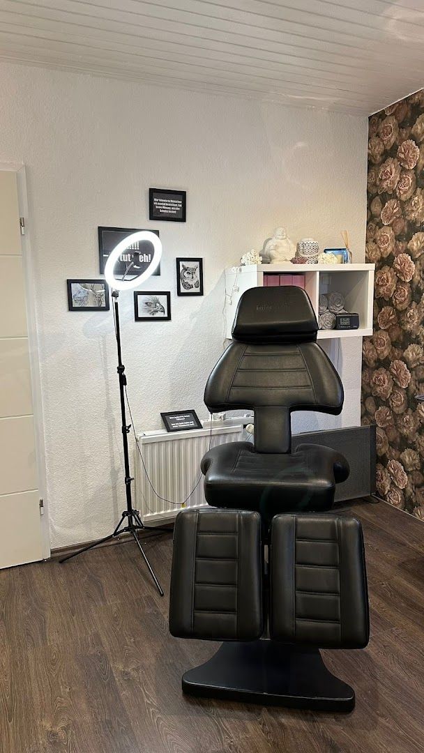 a black chair in a room with a wallpapered wall