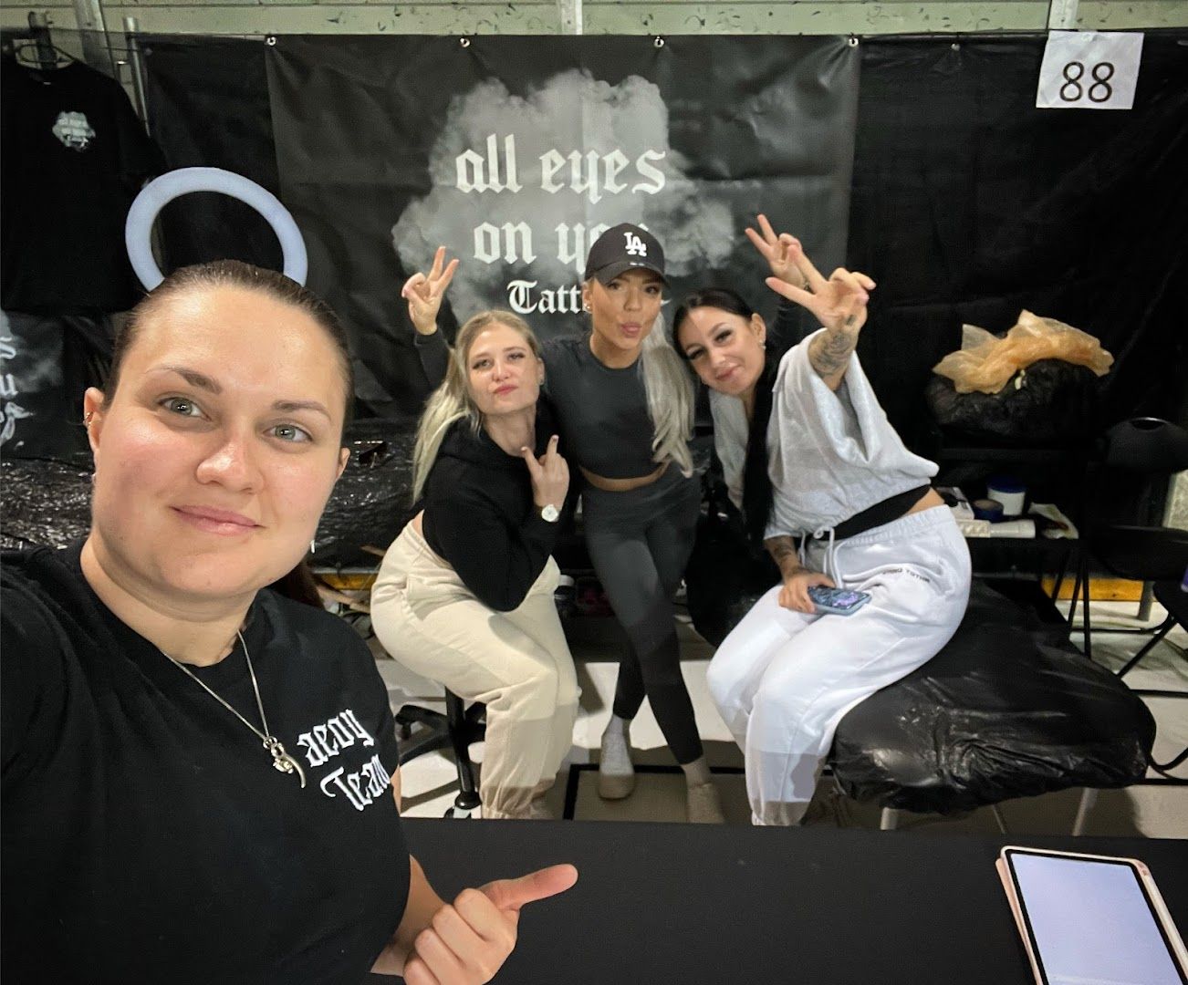 three women sitting at a table with one pointing up