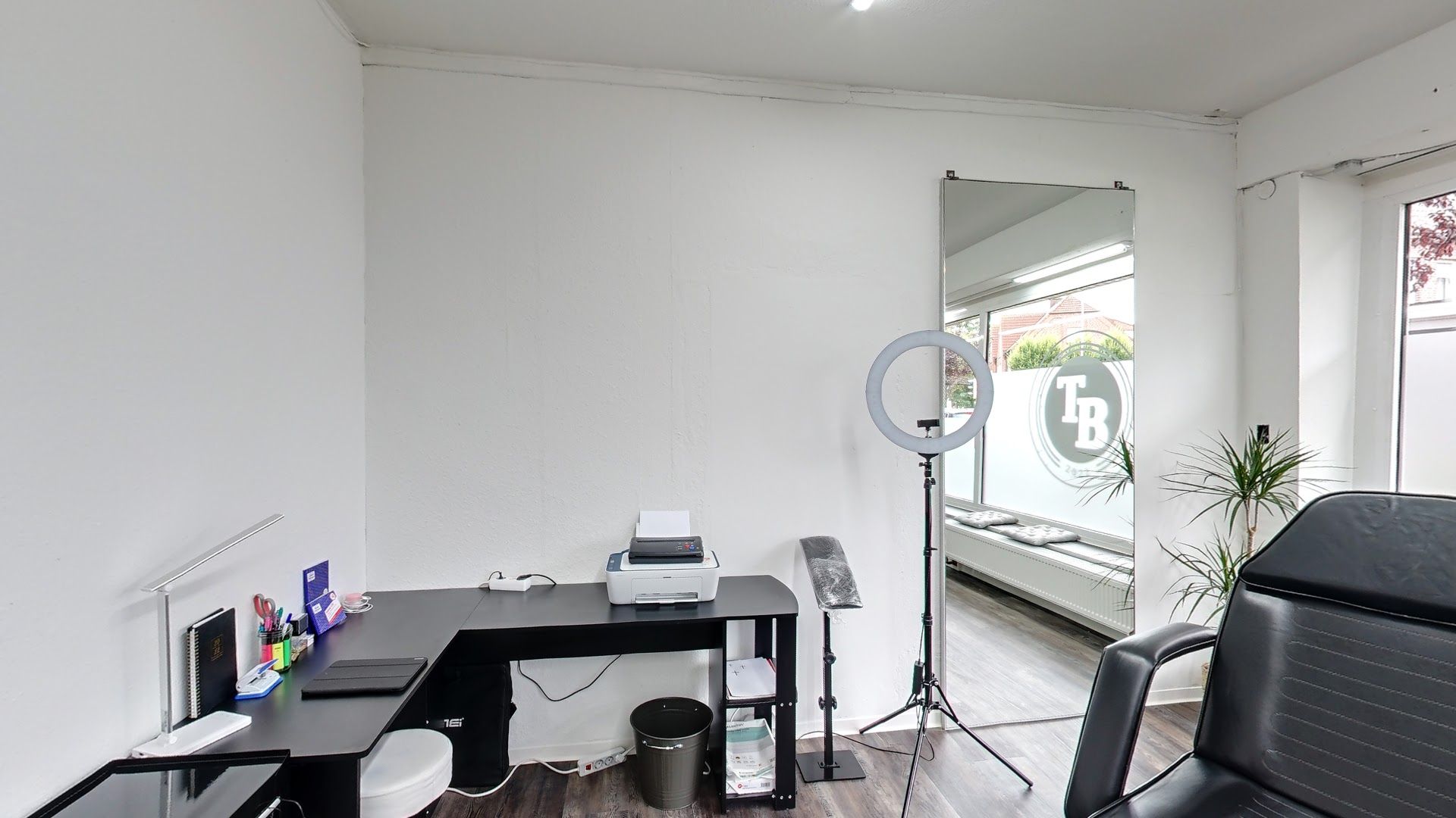 a room with a desk, chair and television