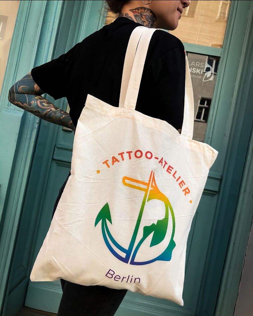 a woman carrying a tote bag with the logo of a japanische tattoos in leipzig shop, berlin, germany