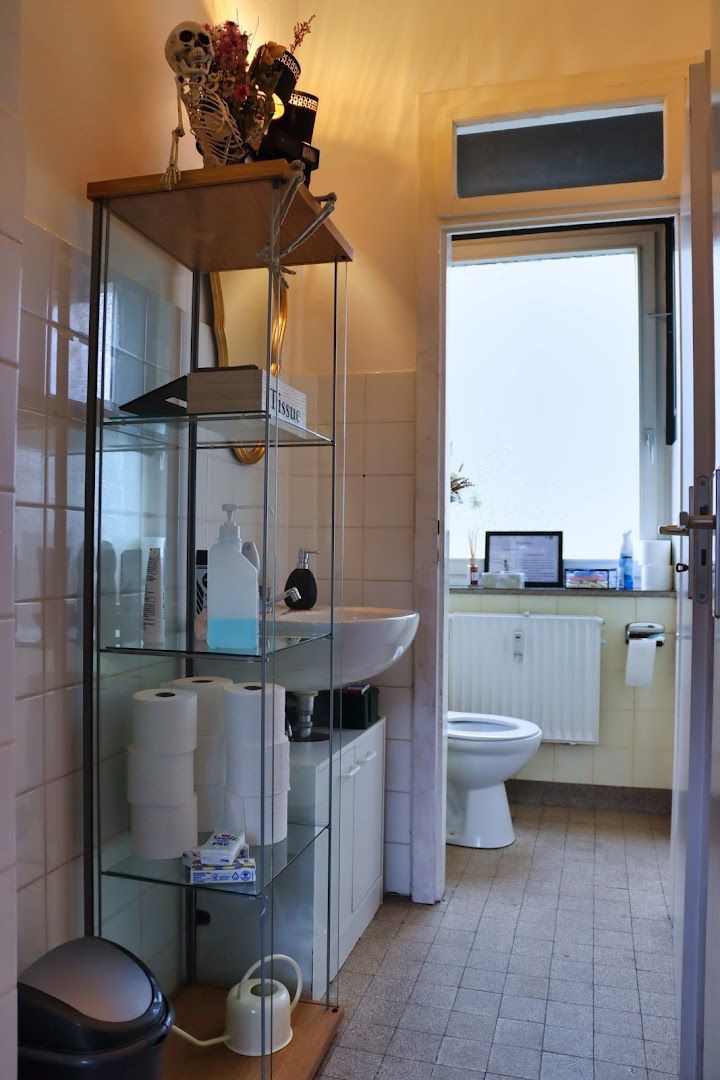 a bathroom with a toilet, sink and a window