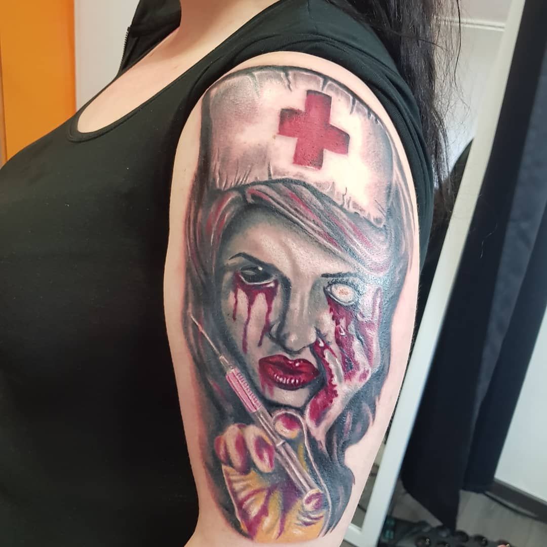 a woman with a bloody face and a cross on her arm