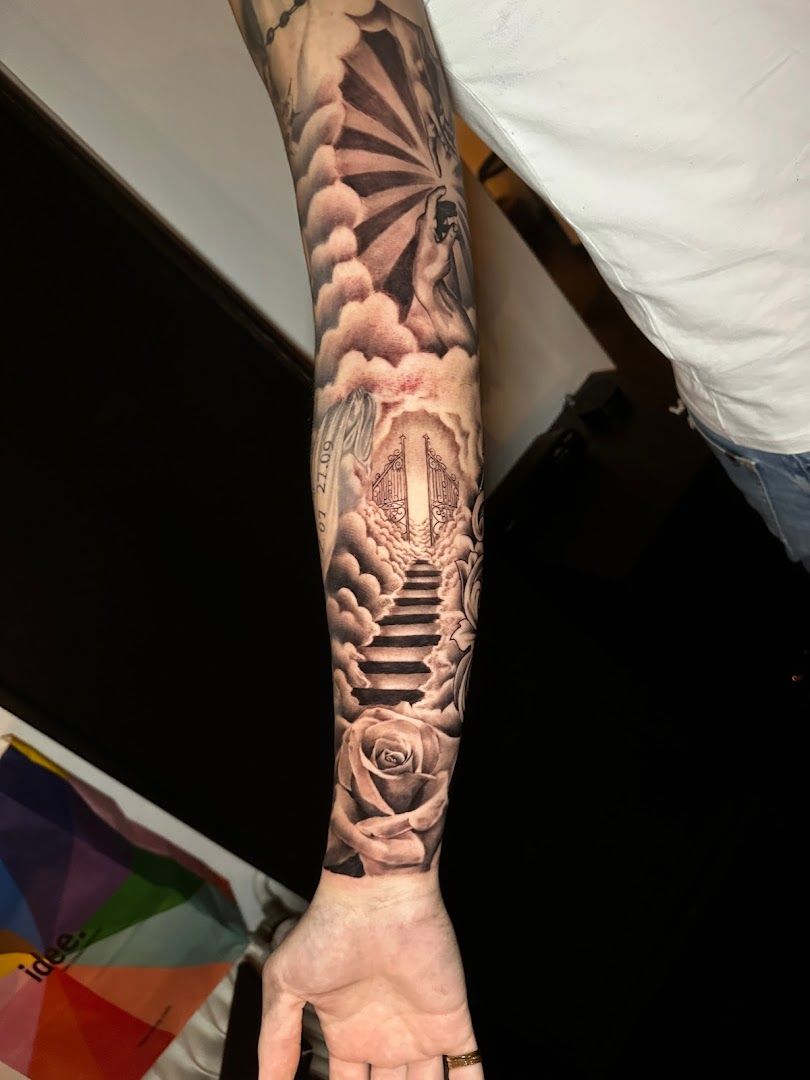 a man's arm with a japanische tattoos in leipzig of a castle and clouds, kassel, germany