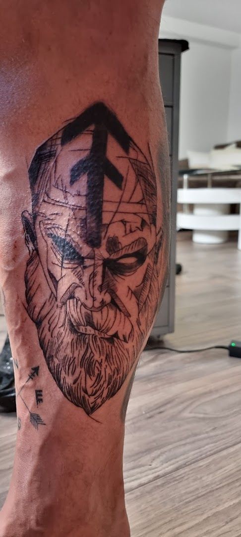 a man's leg with a cover-up tattoo of a face, peine, germany