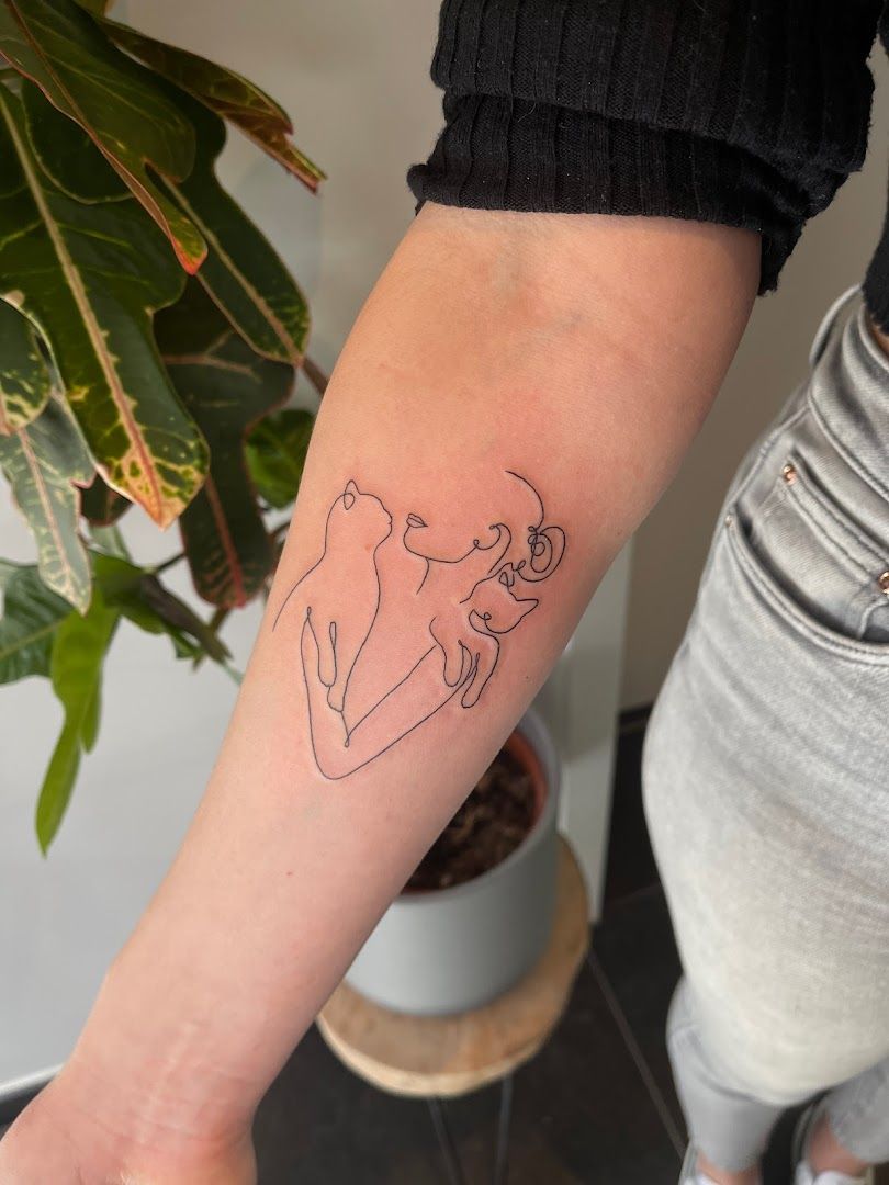 a woman's arm with a small cover-up tattoo of a dog, biberach, germany